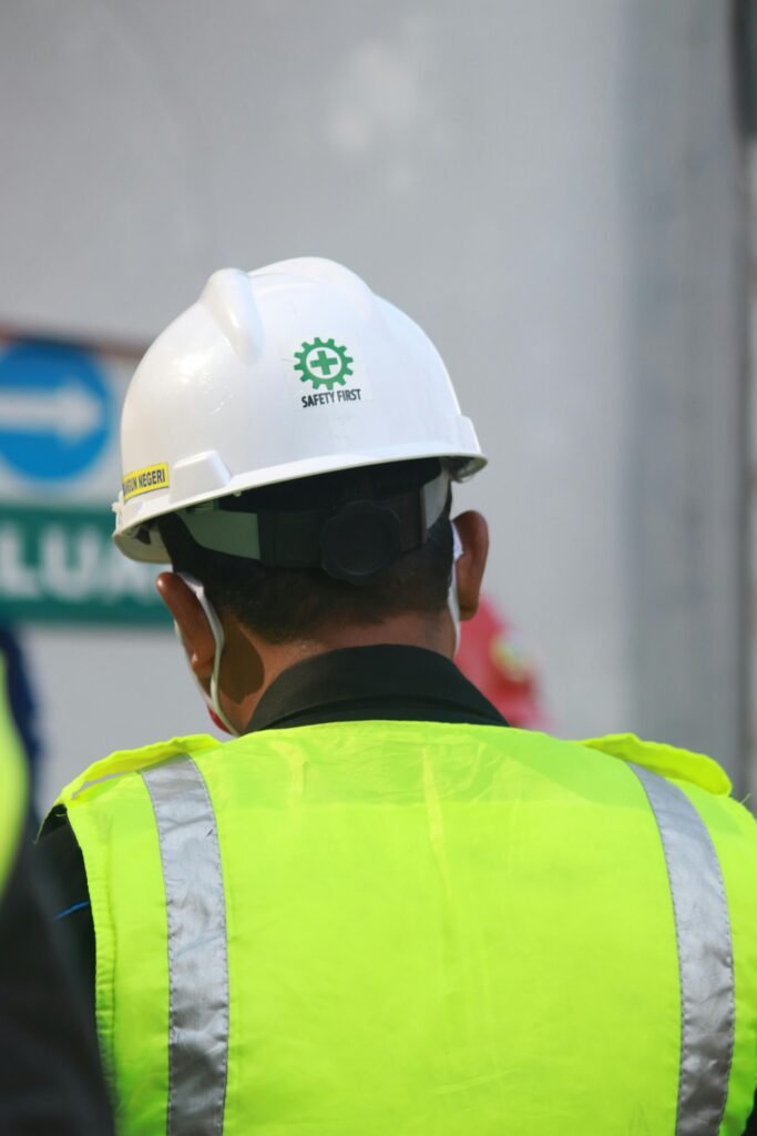 Worker with safety vest and helmet at a construction site in Central Java, Indonesia.